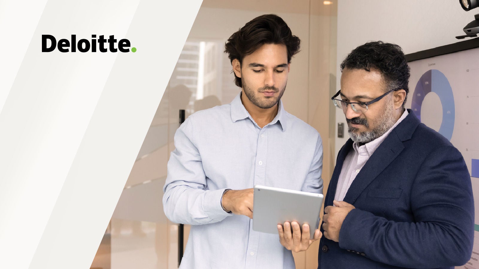 Two professionals reviewing a tablet in an office, with the Deloitte logo displayed.