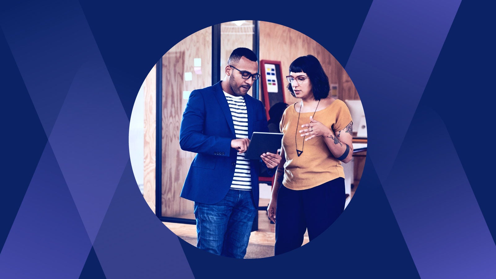 Two coworkers talking looking at a tablet