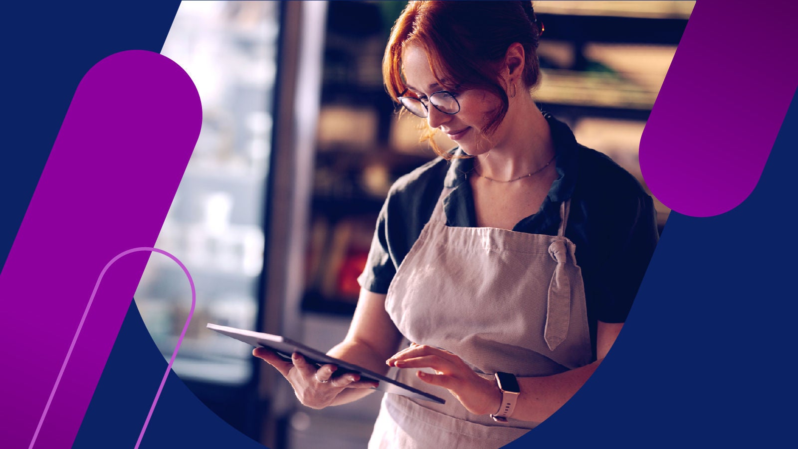 Woman wearing an apon in a store looking at a tablet