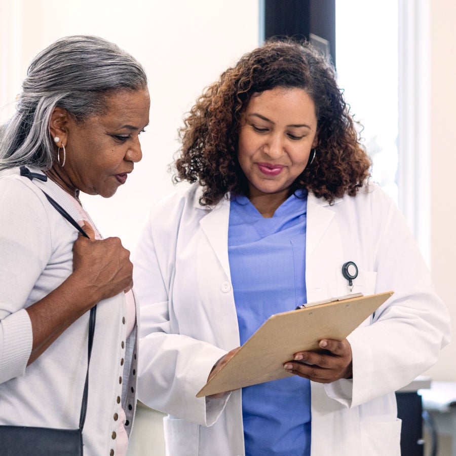 Two women in white coats engaged in conversation, showcasing a professional and collaborative atmosphere.