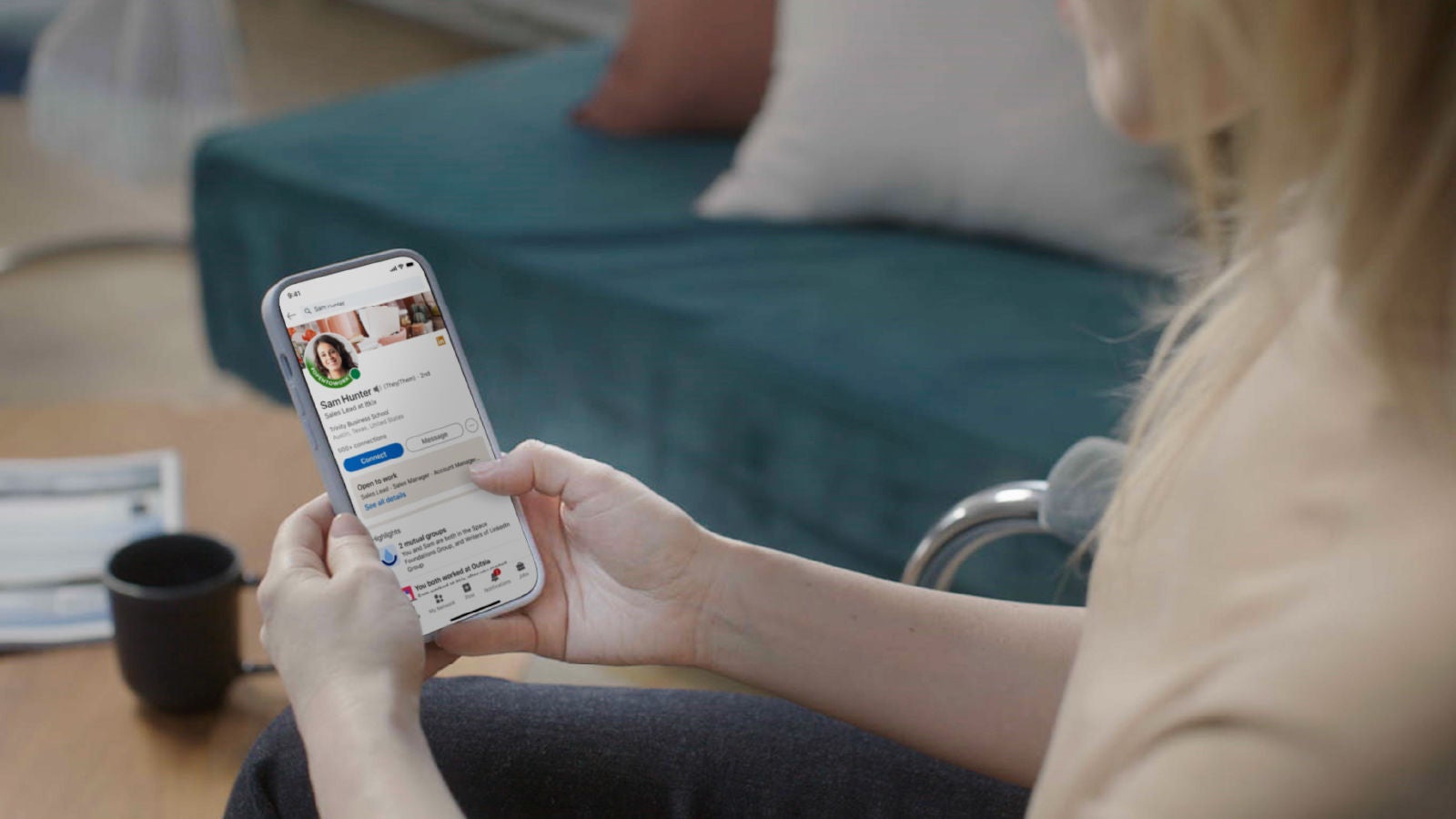 Bild einer Frau, die sich auf ihrem Smartphone ein LinkedIn-Profil ansieht