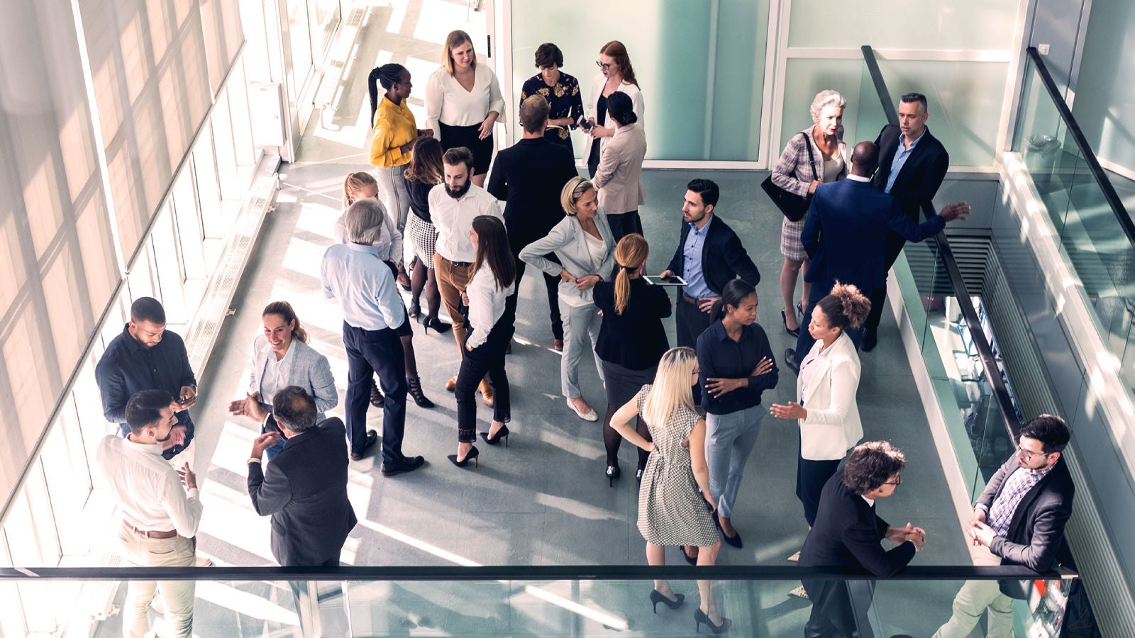 Aerial image of a large group of coworkers mingling in an office space
