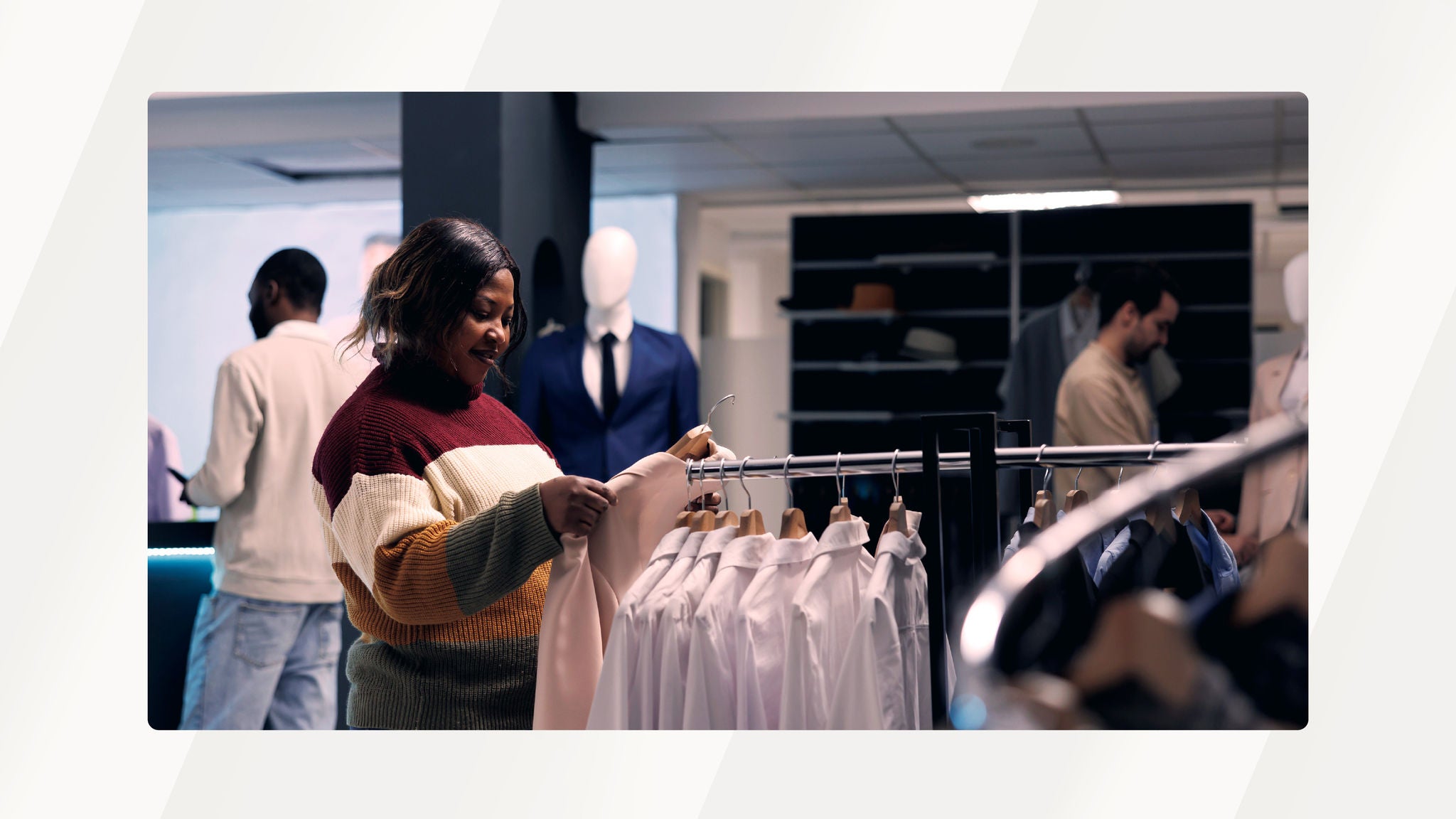 A woman browsing clothing on a rack inside a retail store, examining a light-colored garment while other shoppers and mannequins are visible in the background.