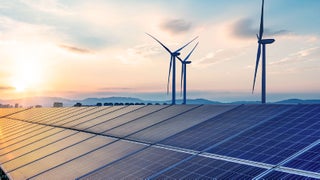 A picturesque sunset highlights solar panels and wind turbines, symbolizing the beauty of sustainable energy solutions.