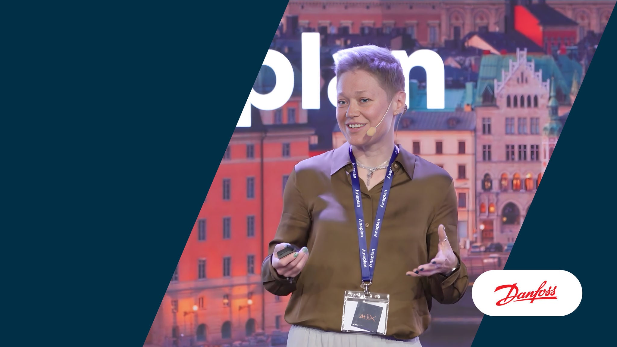 Speaker from Danfoss presenting on stage with Danfoss logo on the lower right