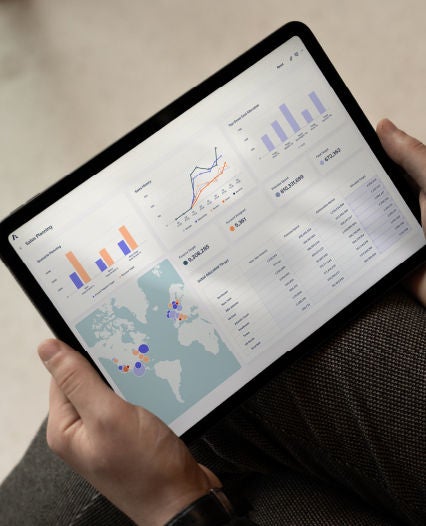 An individual engaged with a laptop, which features a graph, suggesting research or solutions tracking.