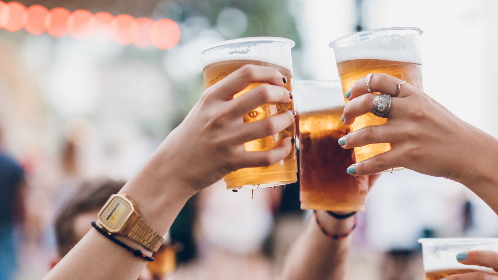 Grouping of hands holding glasses of been in the air to "cheers"