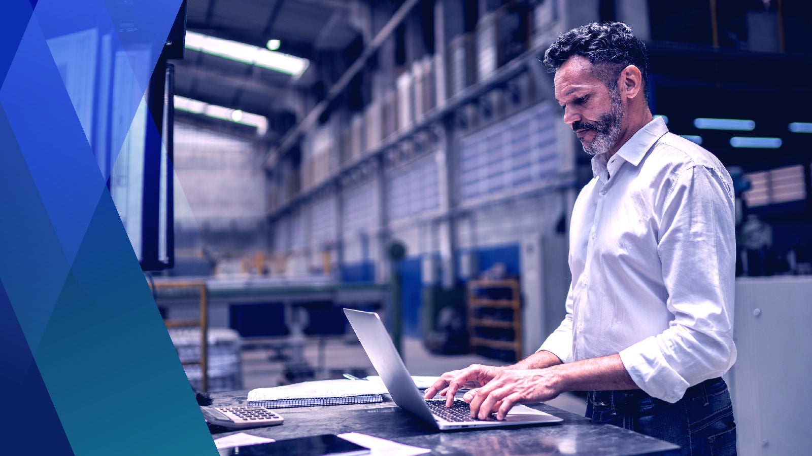 Man working on a laptop in a warehouse