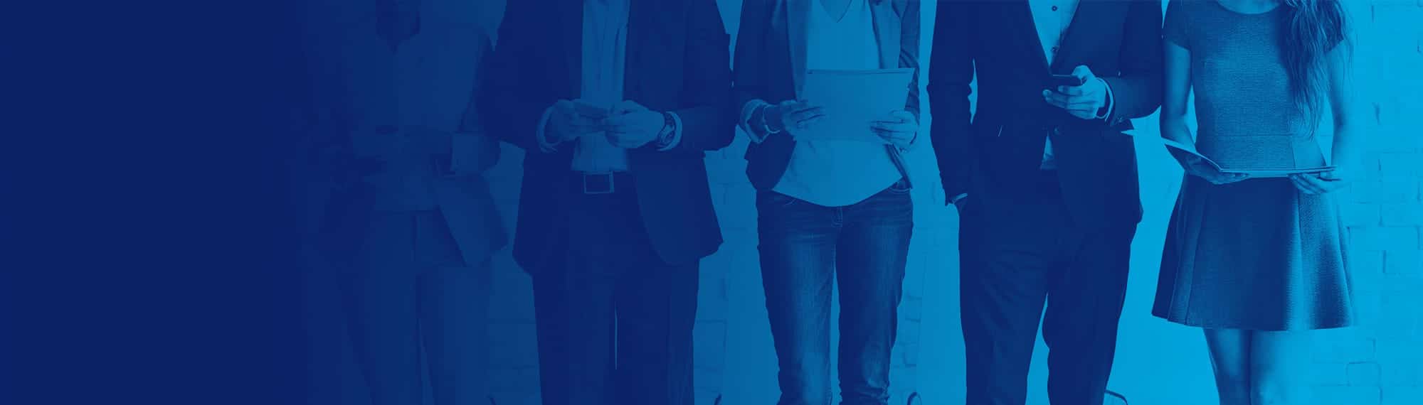 Group of people standing in a line looking at different digital devices