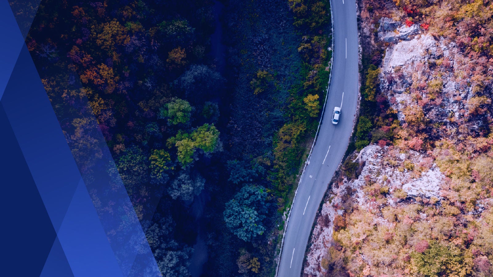 Aerial view of a car driving down a winding road 