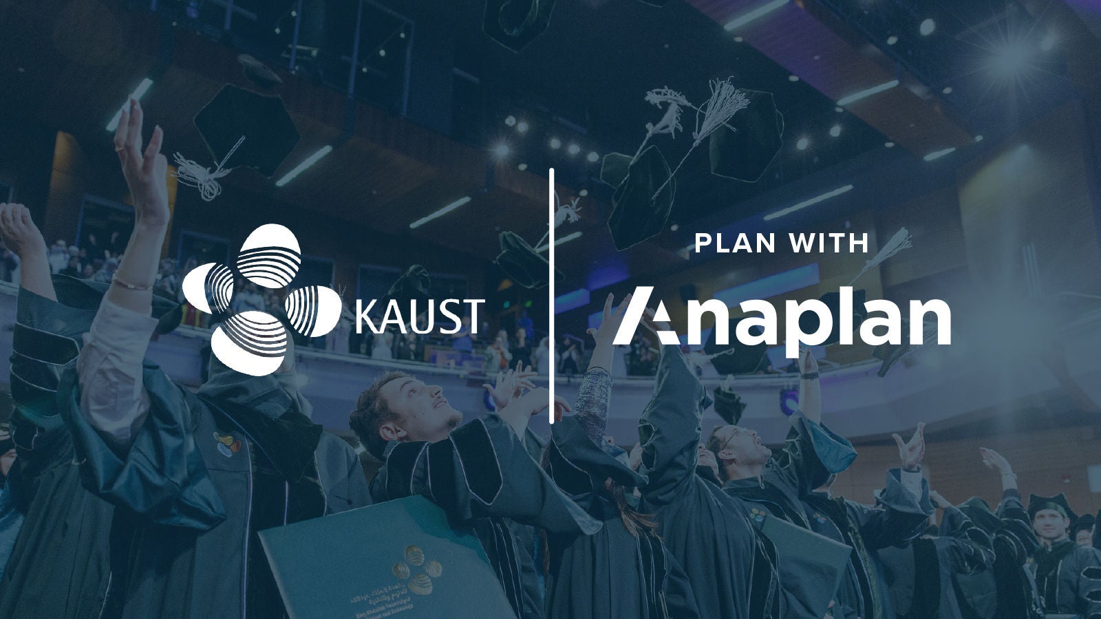 KAUST and Anaplan Logos displayed center. Graduates in academic regalia cheer and toss caps in the air inside a modern auditorium.