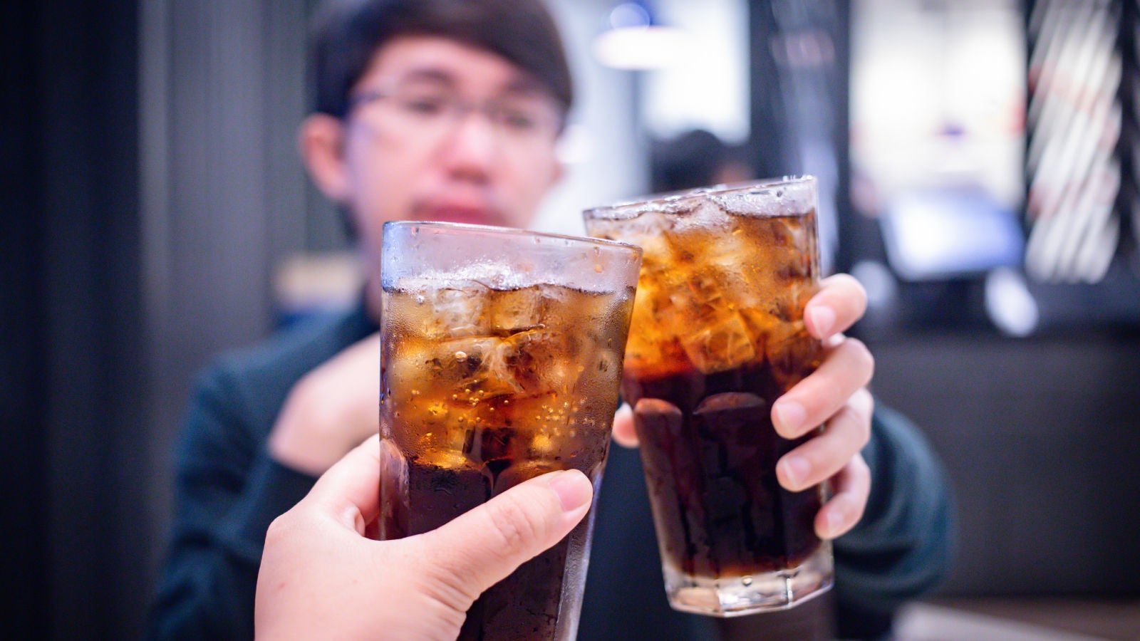Deux personnes qui trinquent avec du Coca-Cola