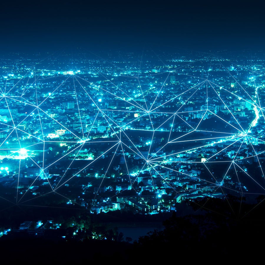 A vibrant network of lights and lines illuminates the cityscape, showcasing urban connectivity and energy at night.