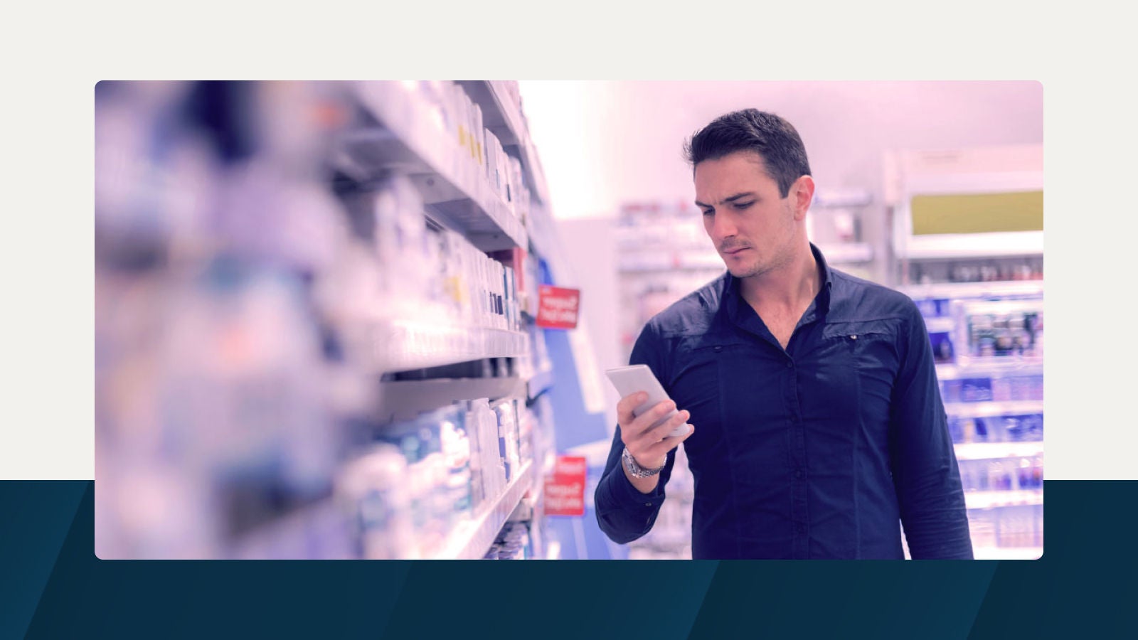 A man in a retail store browsing his phone while shopping, symbolizing data-driven trade promotion planning.