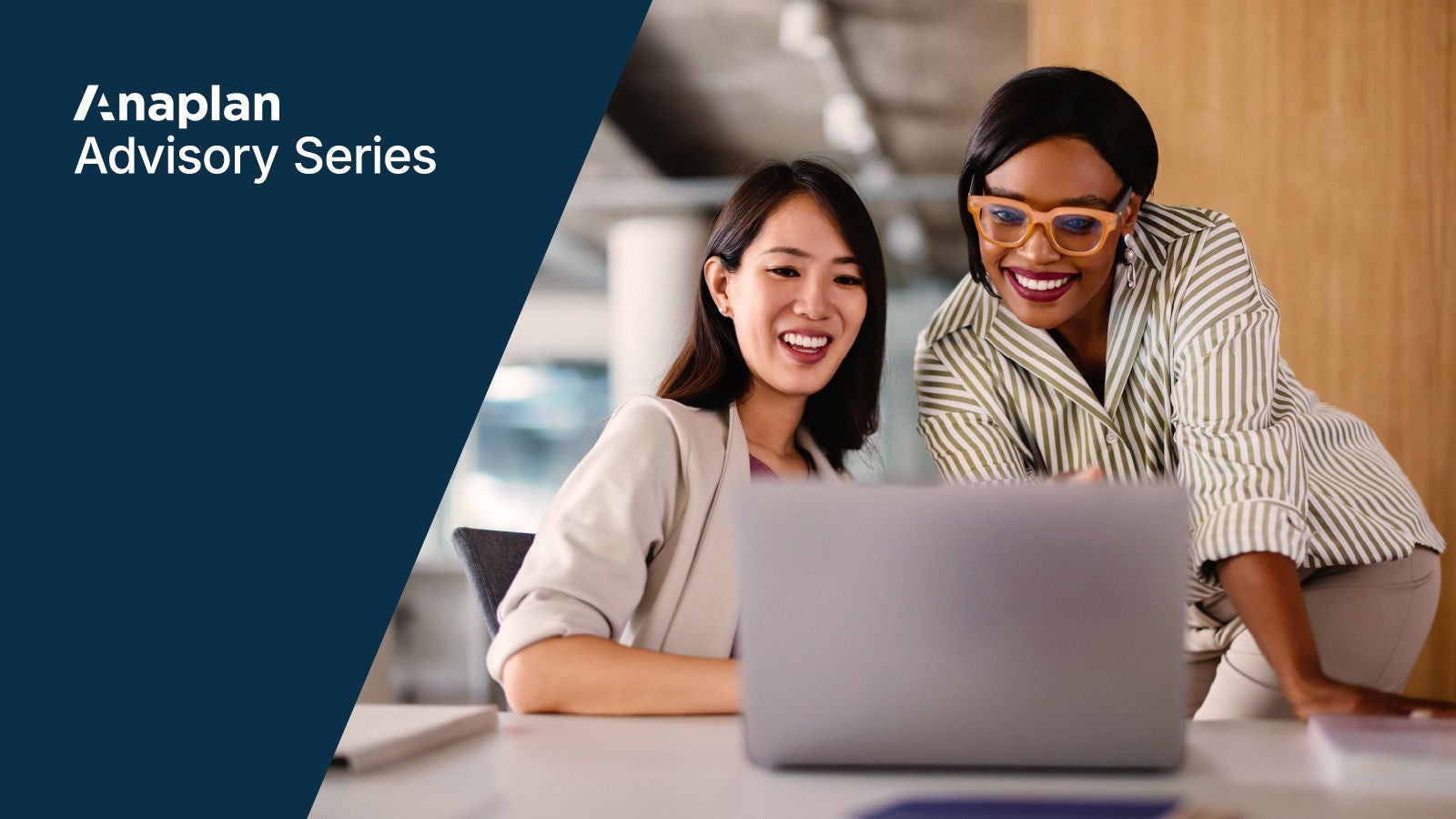 Two smiling professionals collaborating at a desk, looking at a laptop screen. The left side features a navy blue panel with the Anaplan Advisory Series logo.
