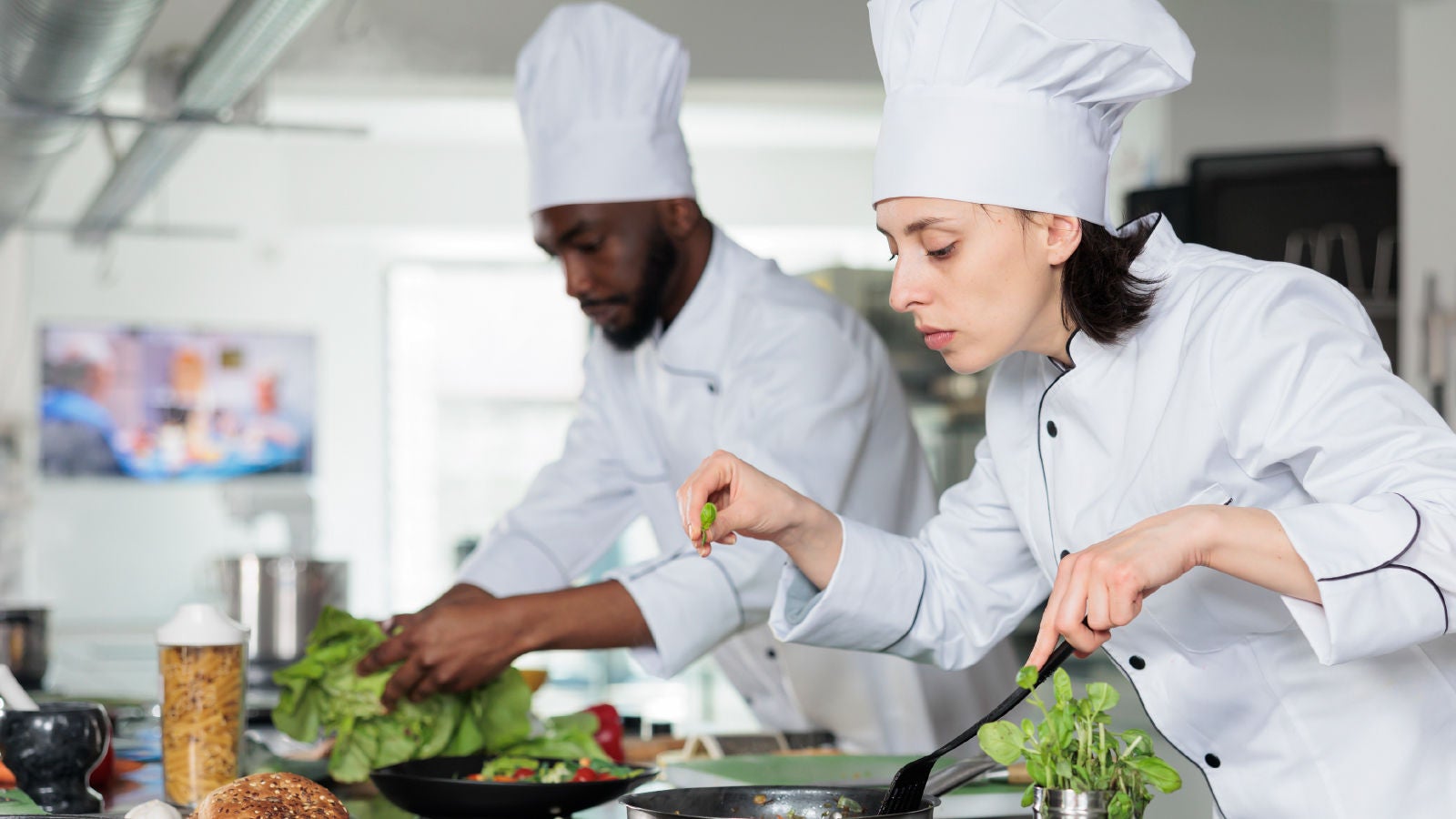 Two chefs preparing and cooking food