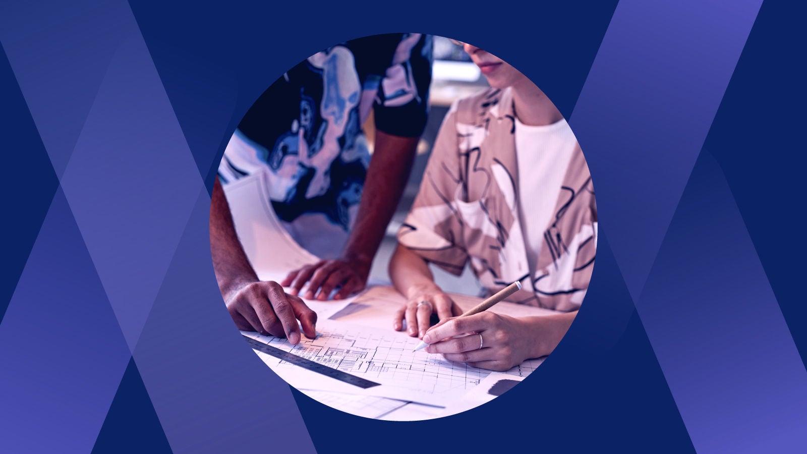 Two co-workers drafting designs together on a desk