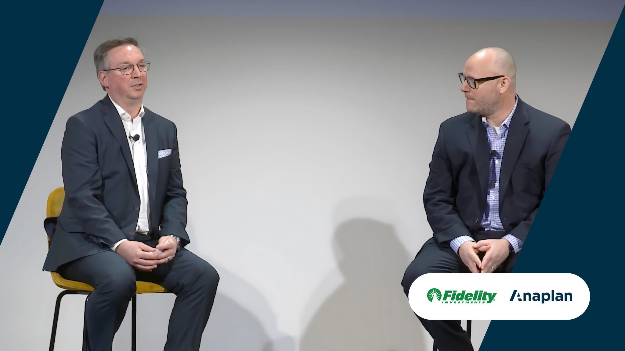 Fidelity and Anaplan Logos displayed bottom right. Two men speak on stage during a session with a white background.