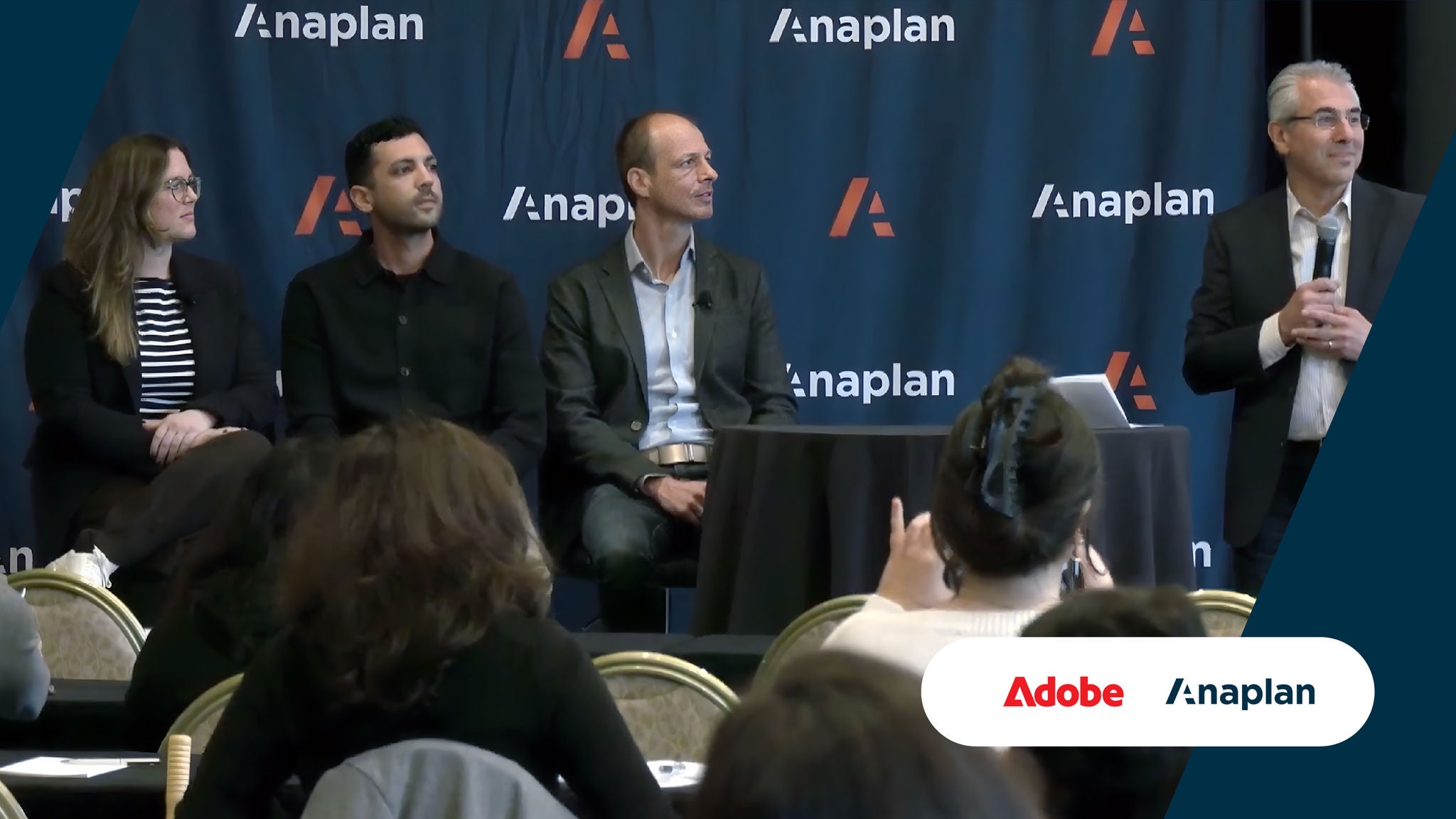 Four speakers participate in a panel discussion in front of an Anaplan-branded backdrop, with Adobe and Anaplan logos displayed.