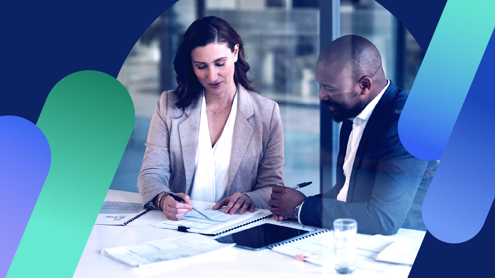 Two coworkers collaborating over financial reporting in an office.  