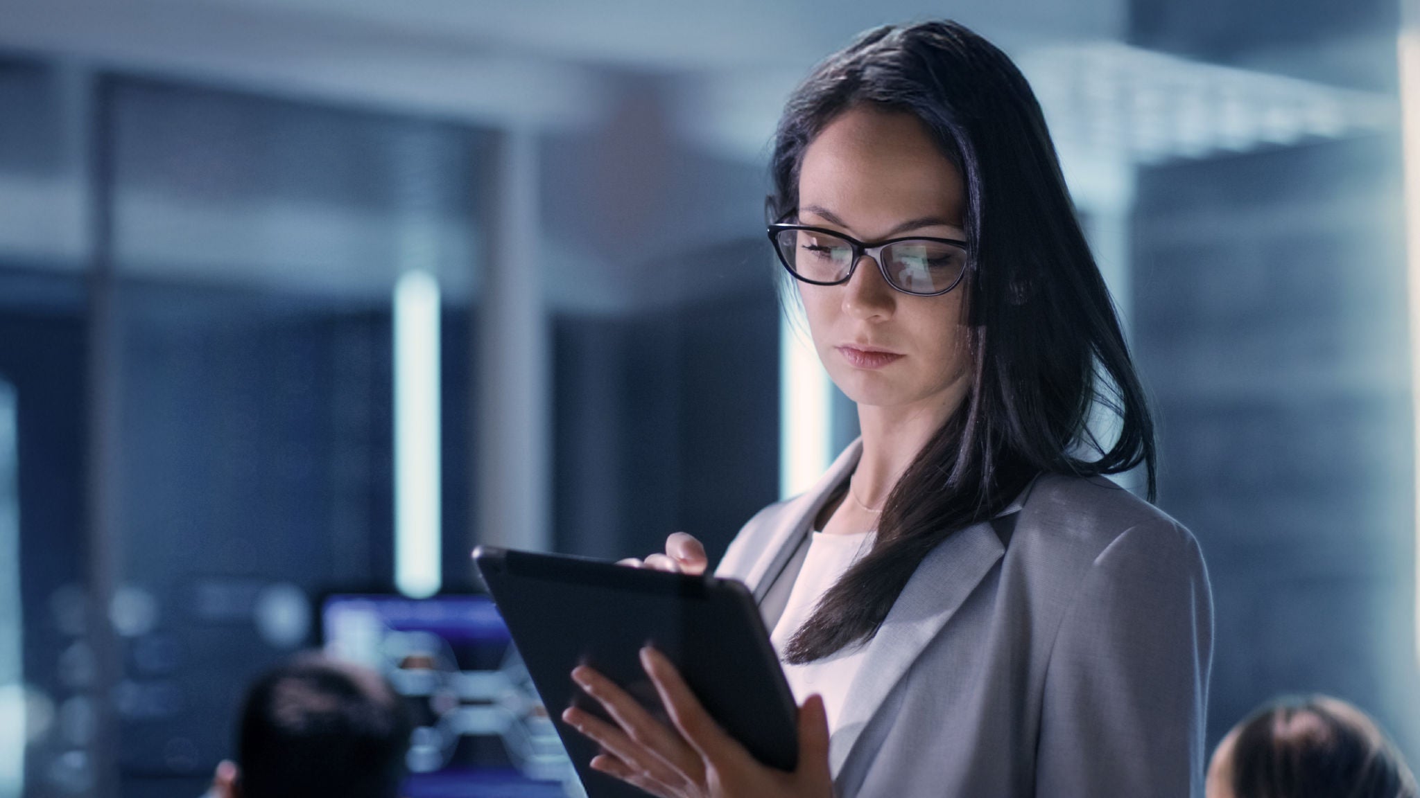 Woman wearing glasses looking at a tablet