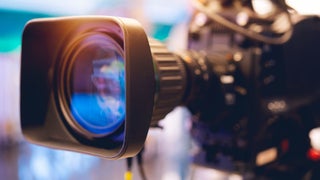 A video camera placed before a standard camera, illustrating the evolution of imaging technology through their designs.
