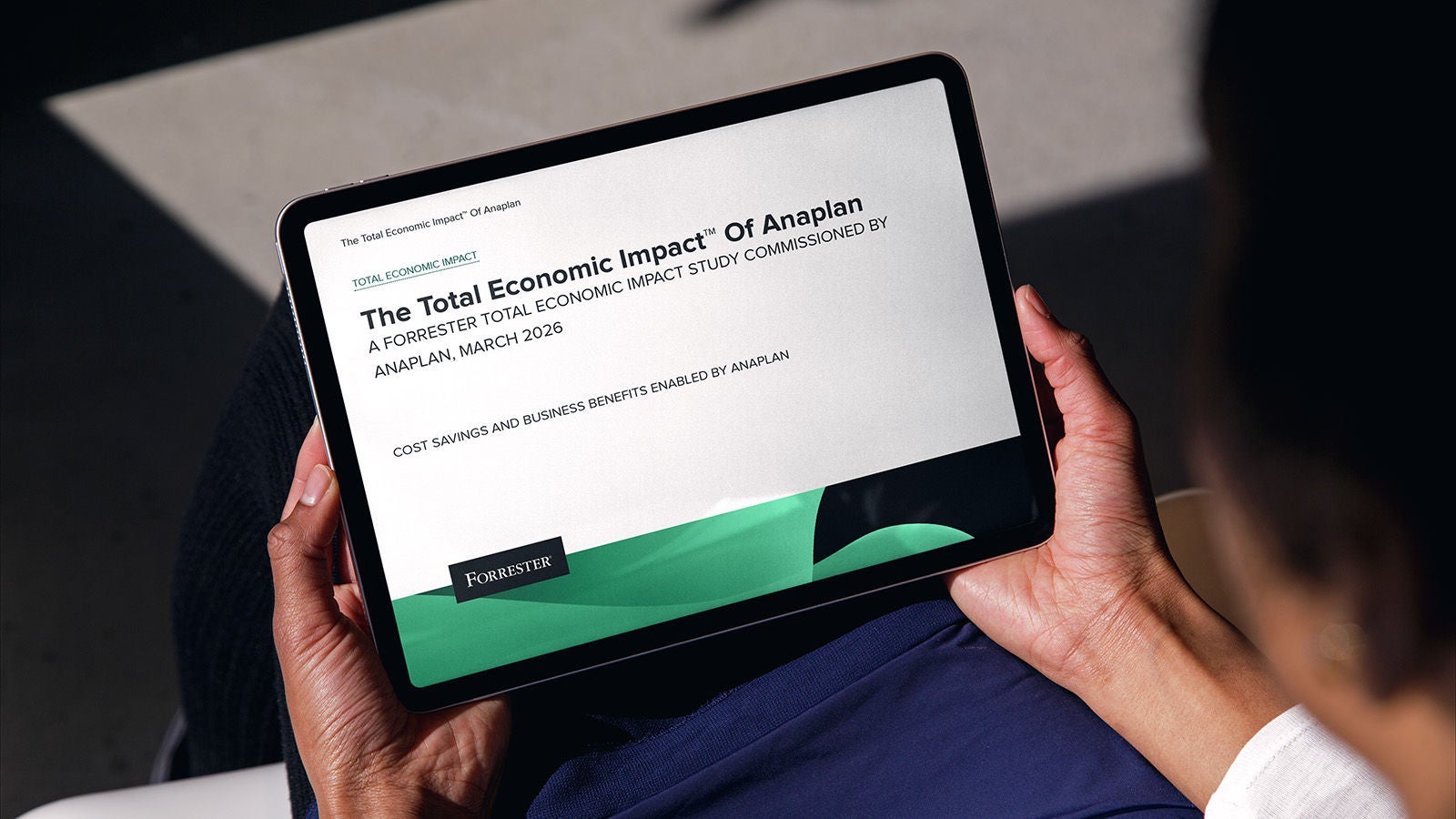 Person holding a tablet displaying The Total Economic Impact™ Of Anaplan, a Forrester Total Economic Impact study commissioned by Anaplan, March 2026.