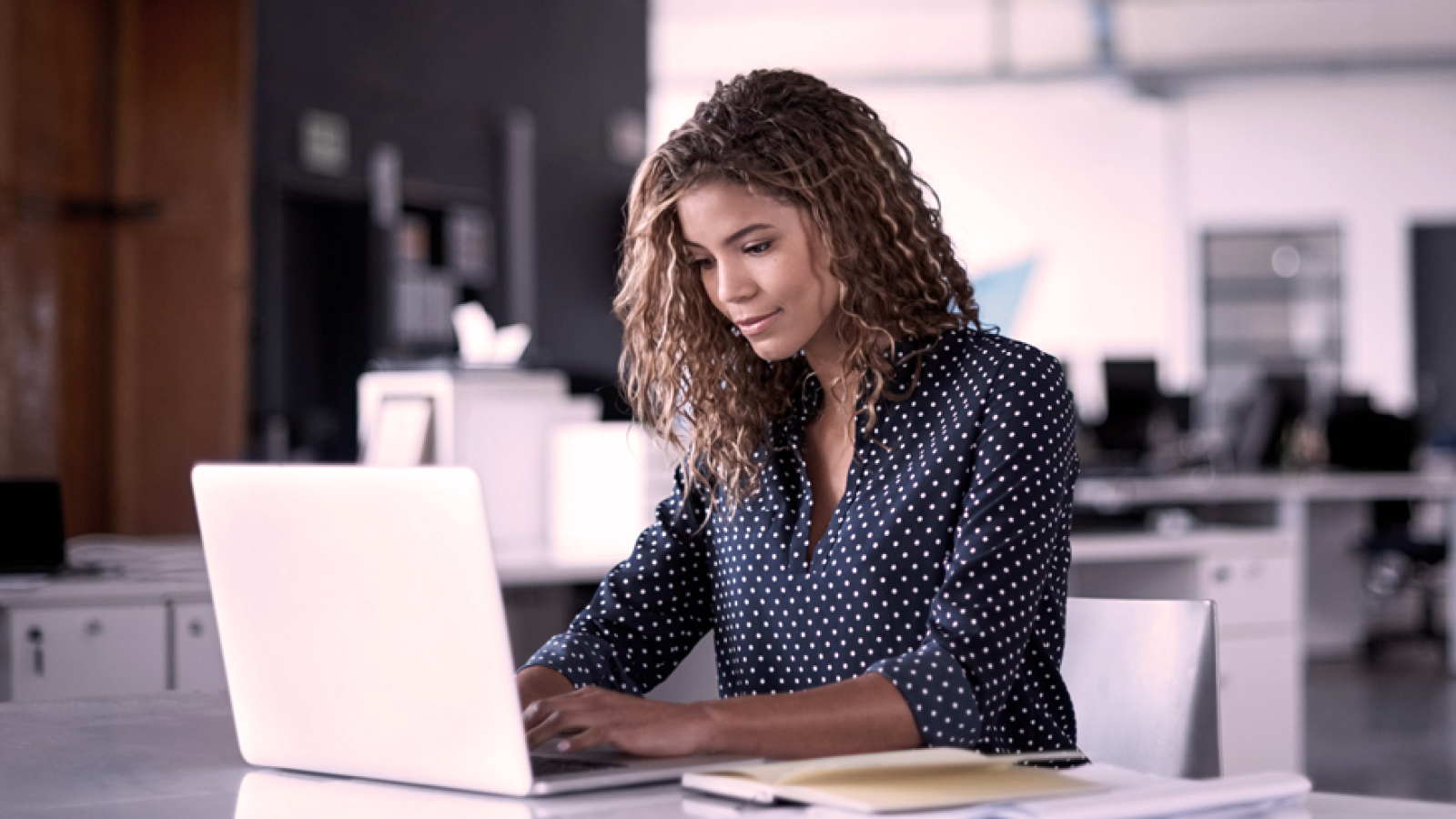 Anaplan white paper on Architecture and Security Controls—promotional graphic showing title text on a blue background beside a photo of a woman working at a laptop, highlighting AIC‑based platform security
