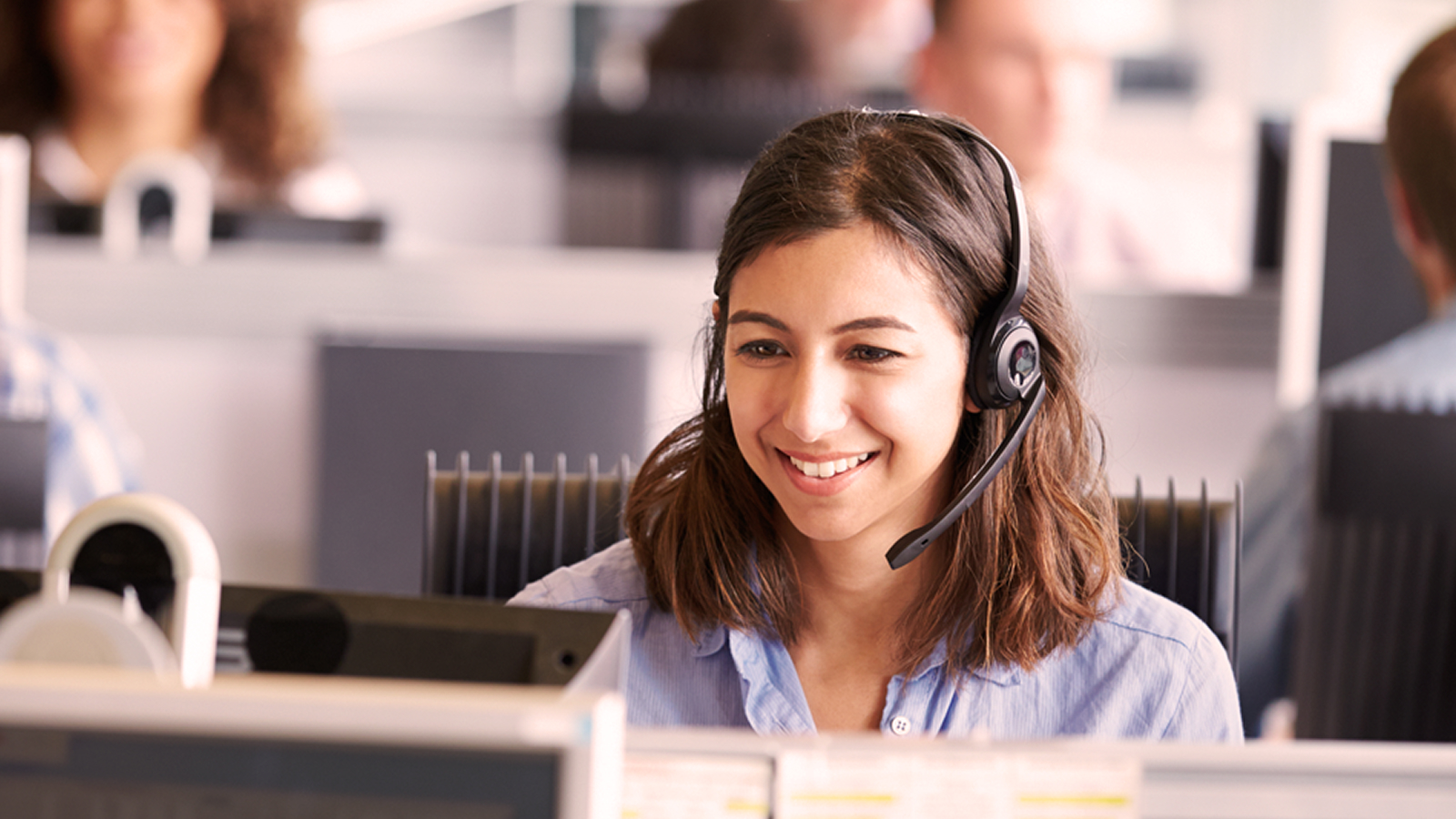 Anaplan ebook on dialing in success for contact center workforce planning. The text highlights closing workforce gaps with modern capacity planning and forecasting, with an image of a smiling woman wearing a headset in a contact center.
