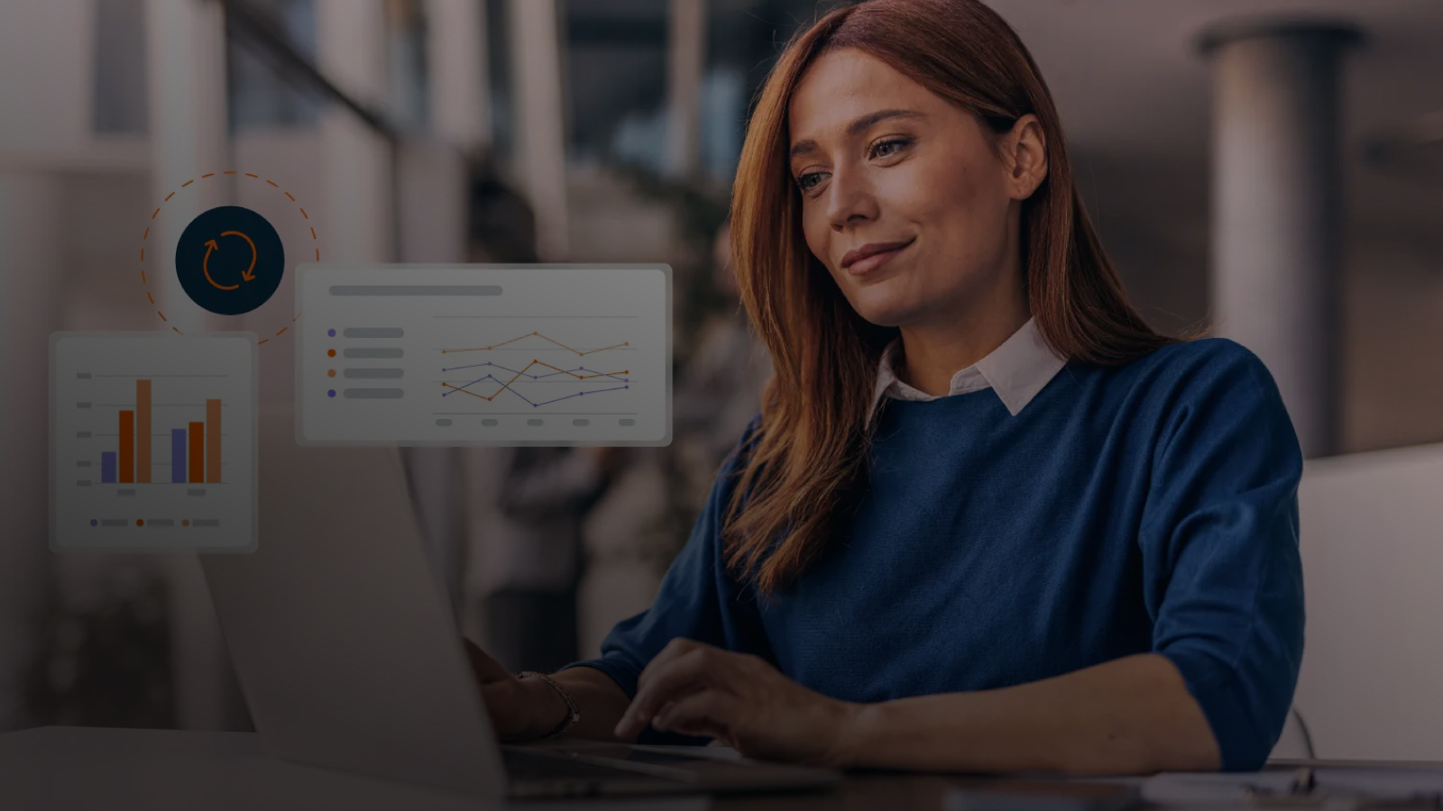 A woman working on a laptop in an office, with semi-transparent digital charts and graphs floating in front of her.