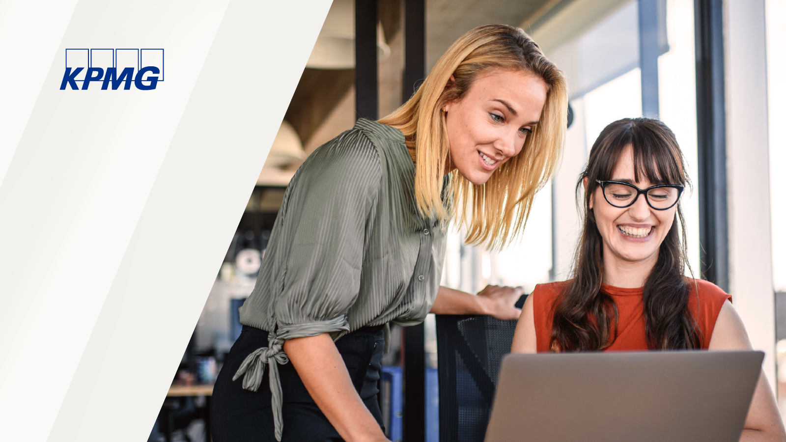 Two professionals collaborate over a laptop in a modern office, with large windows in the background and the KPMG logo visible in the image.