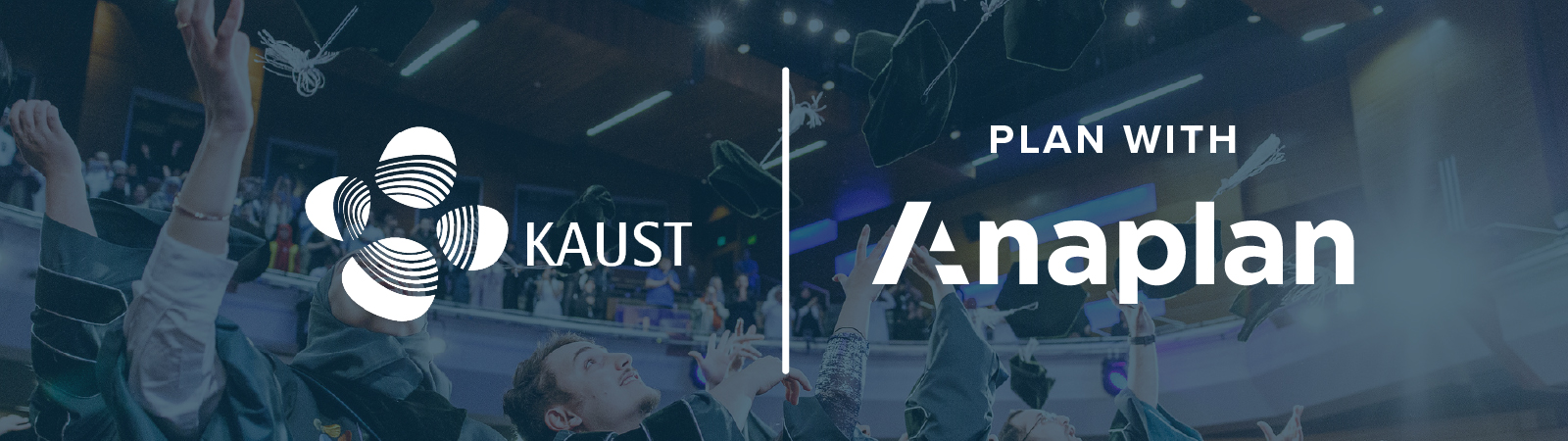 KAUST and Anaplan Logos displayed center. Graduates in academic regalia cheer and toss caps in the air inside a modern auditorium.