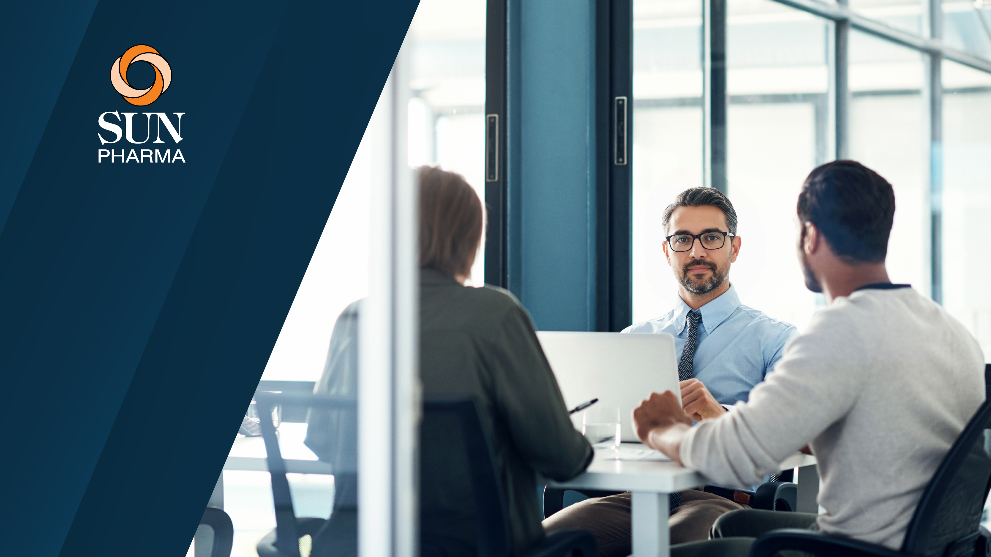The Sun Pharma logo displayed on a dark blue background, alongside an image of three professionals meeting in an office.