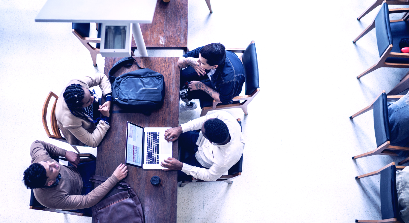 Group of people viewed from above working with laptops in office environment