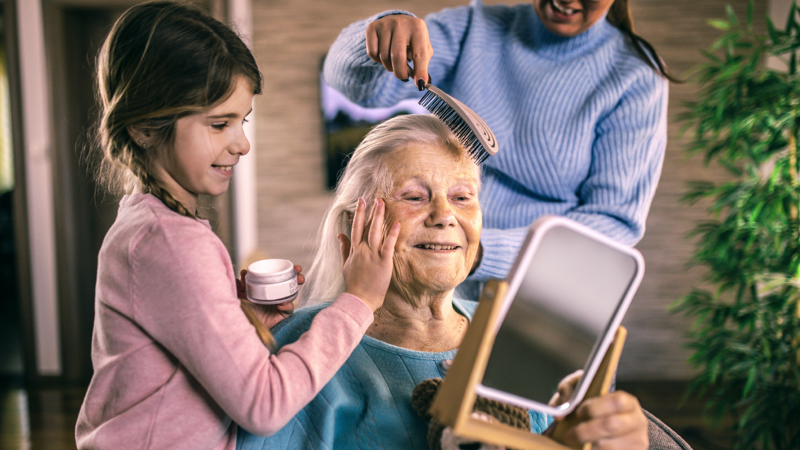 resources-customer-story-images-bayer-consumer-health Older woman looking in mirror while granddaughter applies lotion to her face