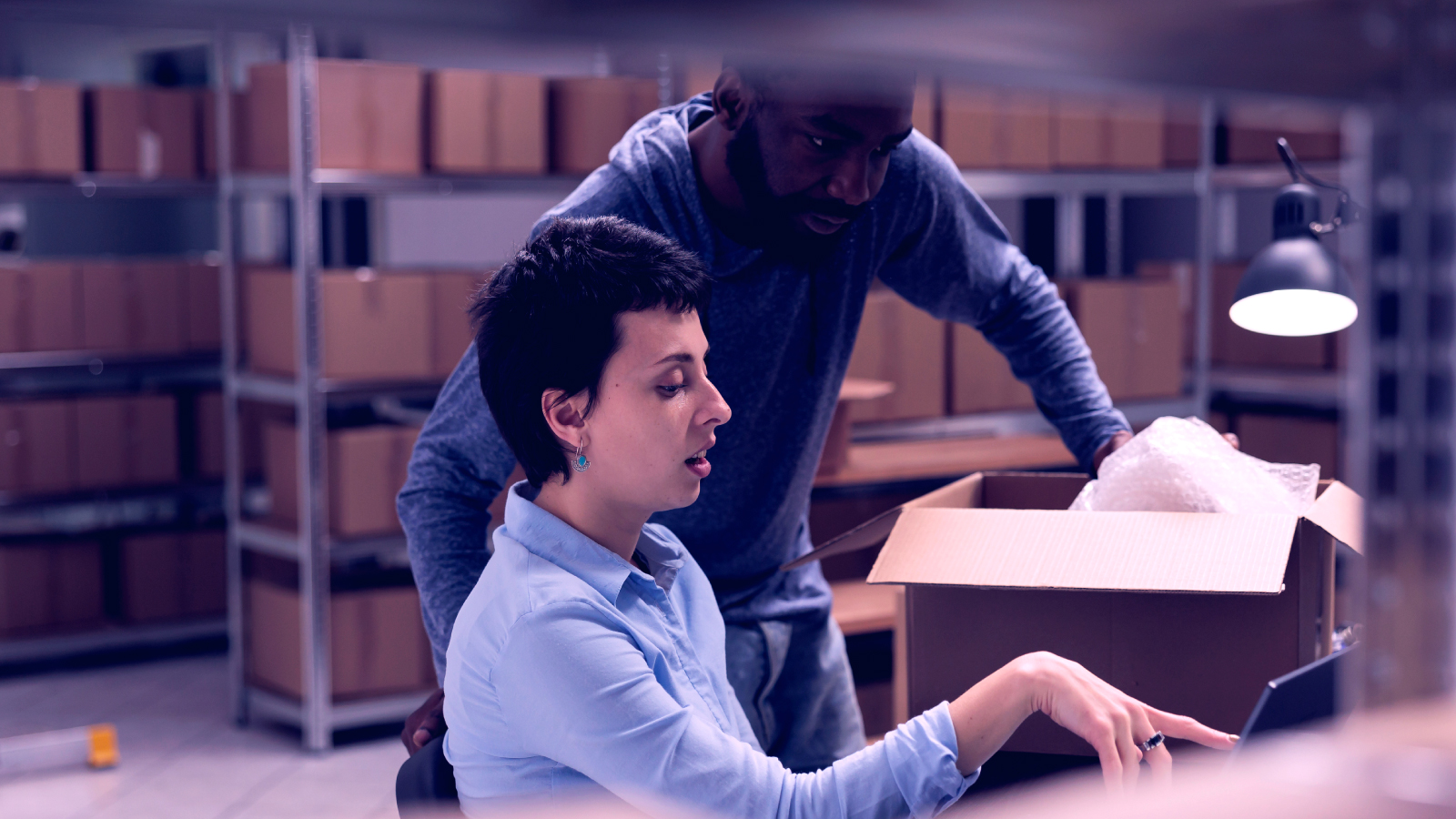 Man on tablet looking over inventory in warehouse