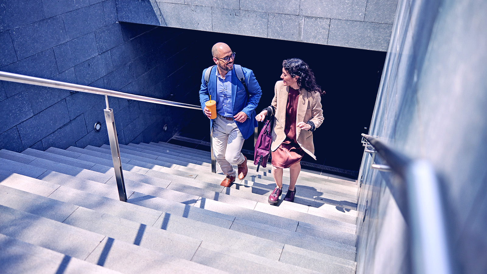 A man and women walking up the steps from a tunnel. 