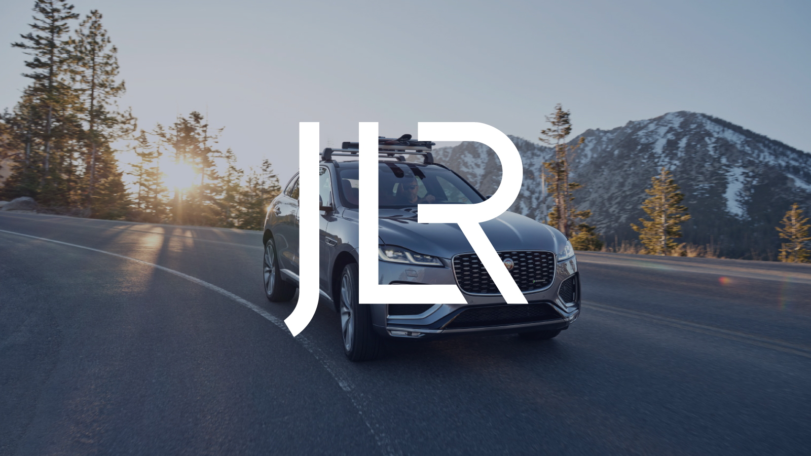 Graphic: JLR logo over Jaguar SUV driving on an open road
