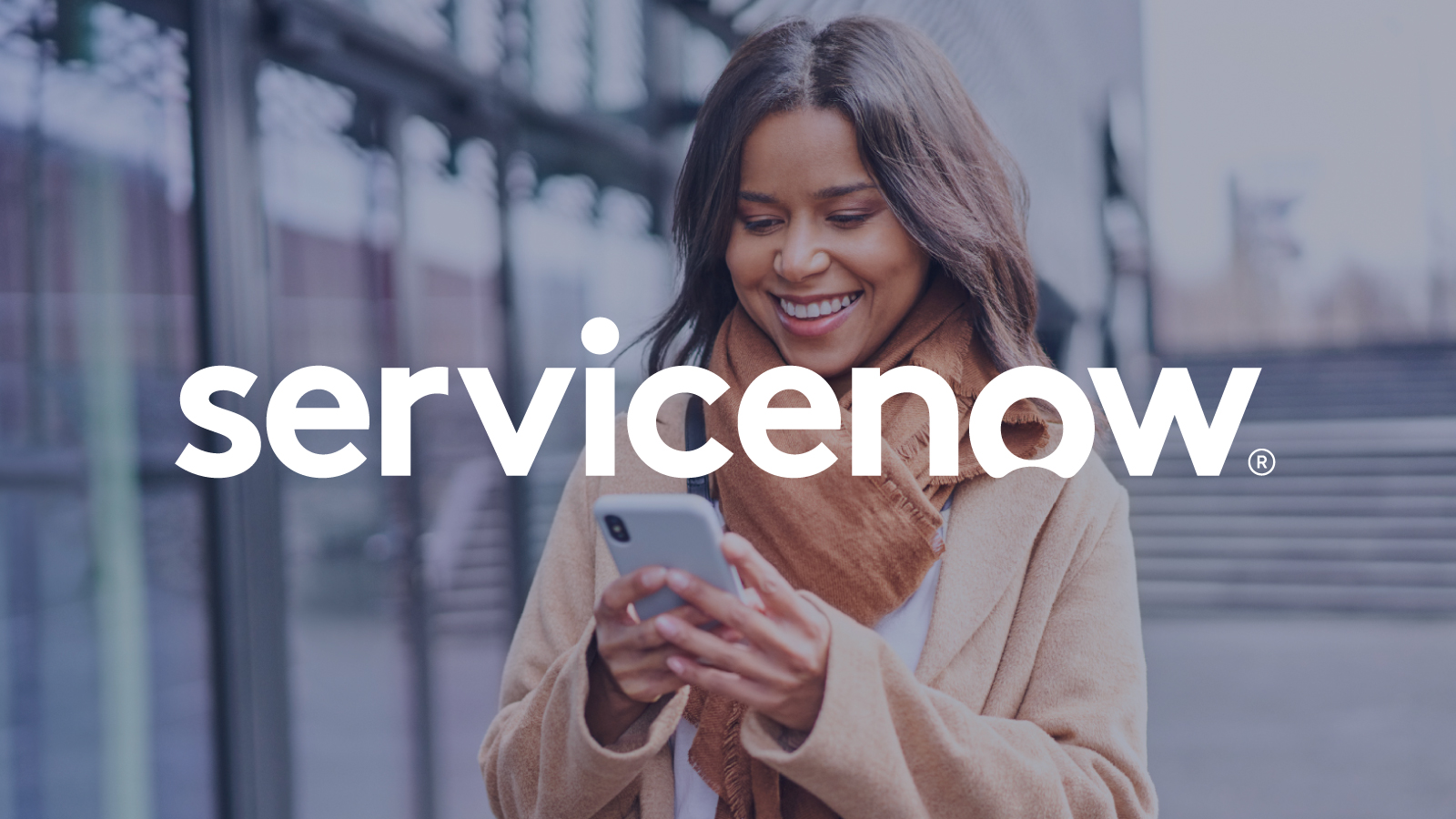 Graphic: ServiceNow logo overlayed on businesswoman walking looking at smartphone