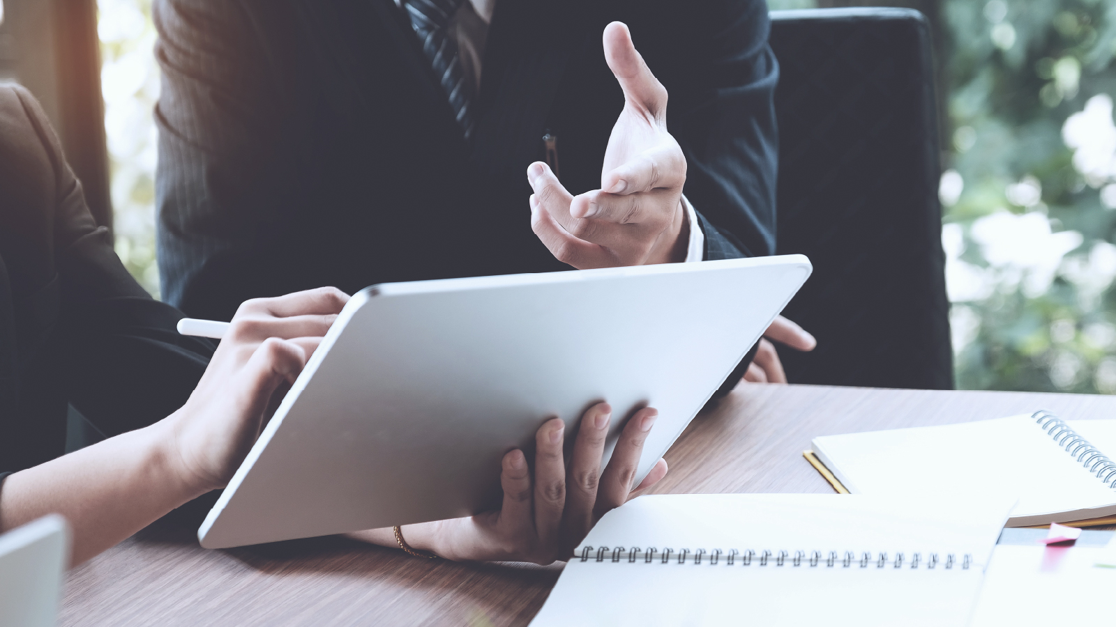resources_customerStory_deloitteGermany 複数の同僚がタブレットを手に会議のテーブルに座っている画像
