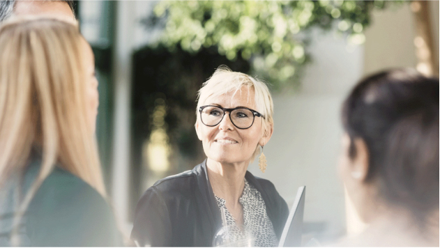Anaplan_CustomerPage_CaseStudy Woman wearing glasses sitting outside