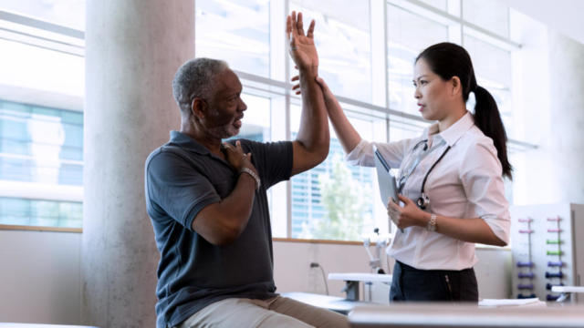 Medical professional holding patients arm up