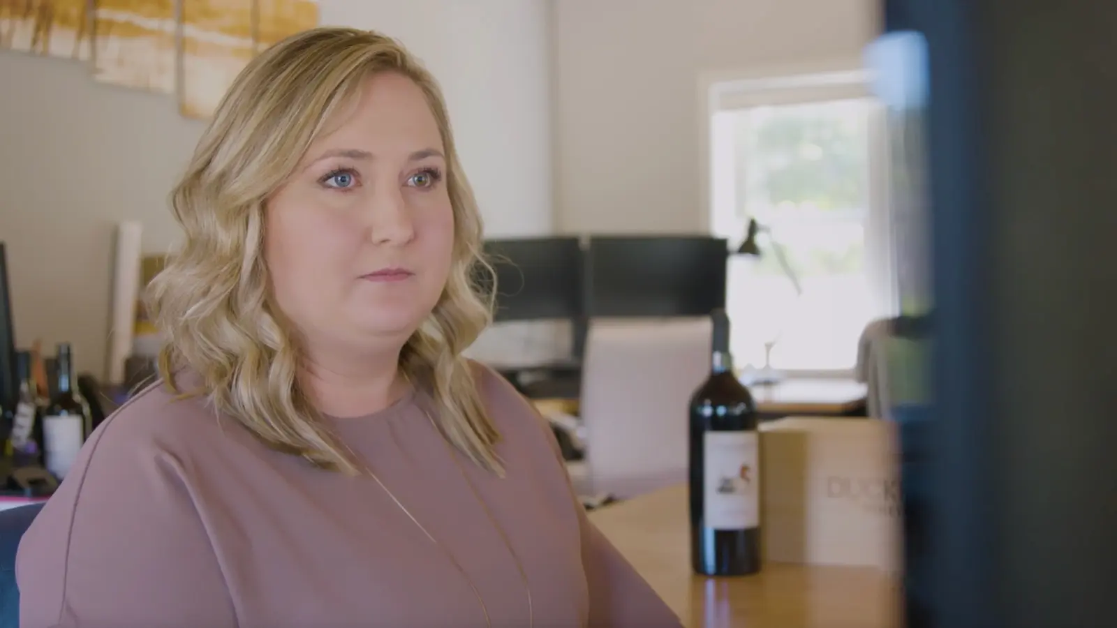 wine sommelier sitting next to a bottle of wine