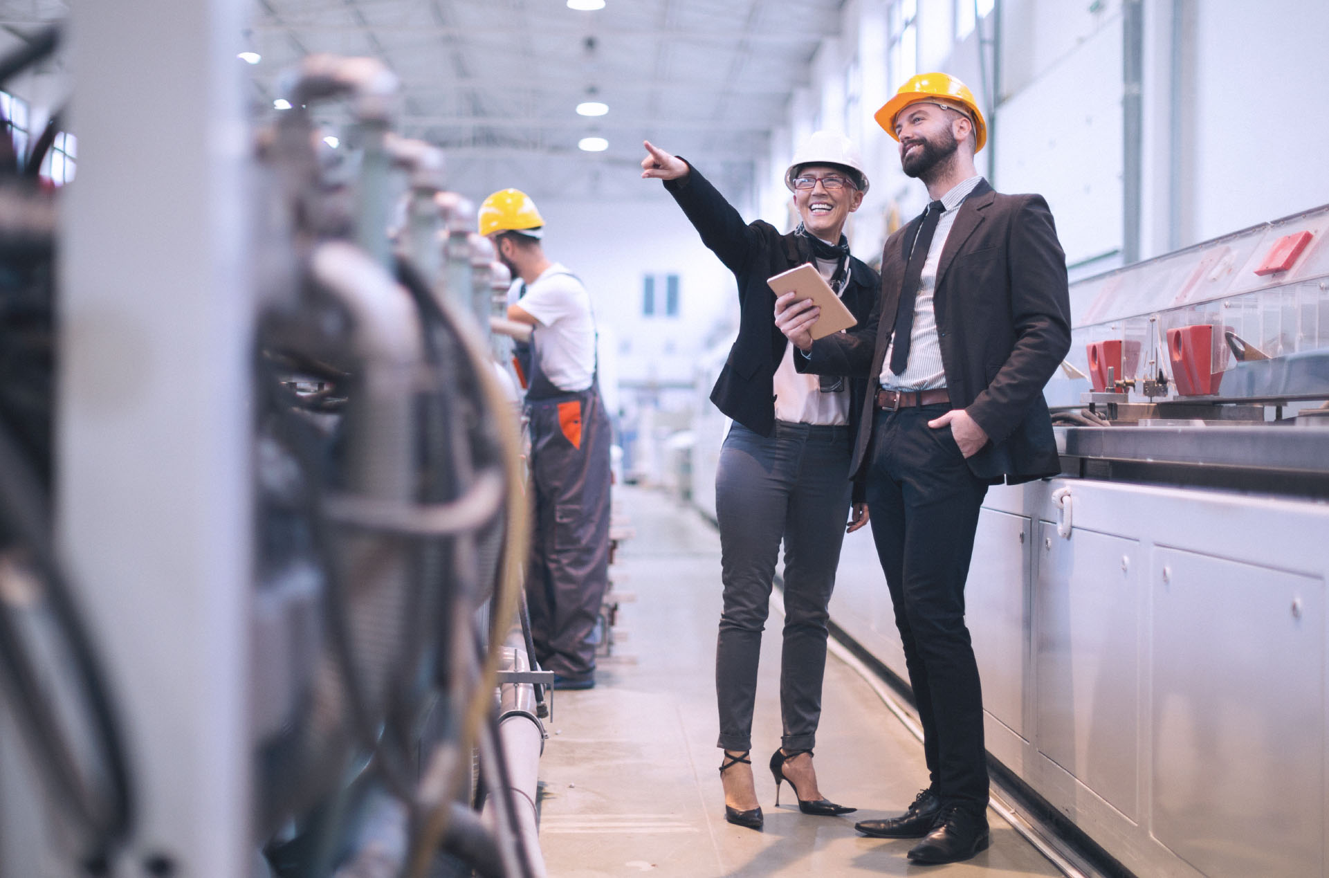 Two male coworkers looking over assembly line in warehouse setting