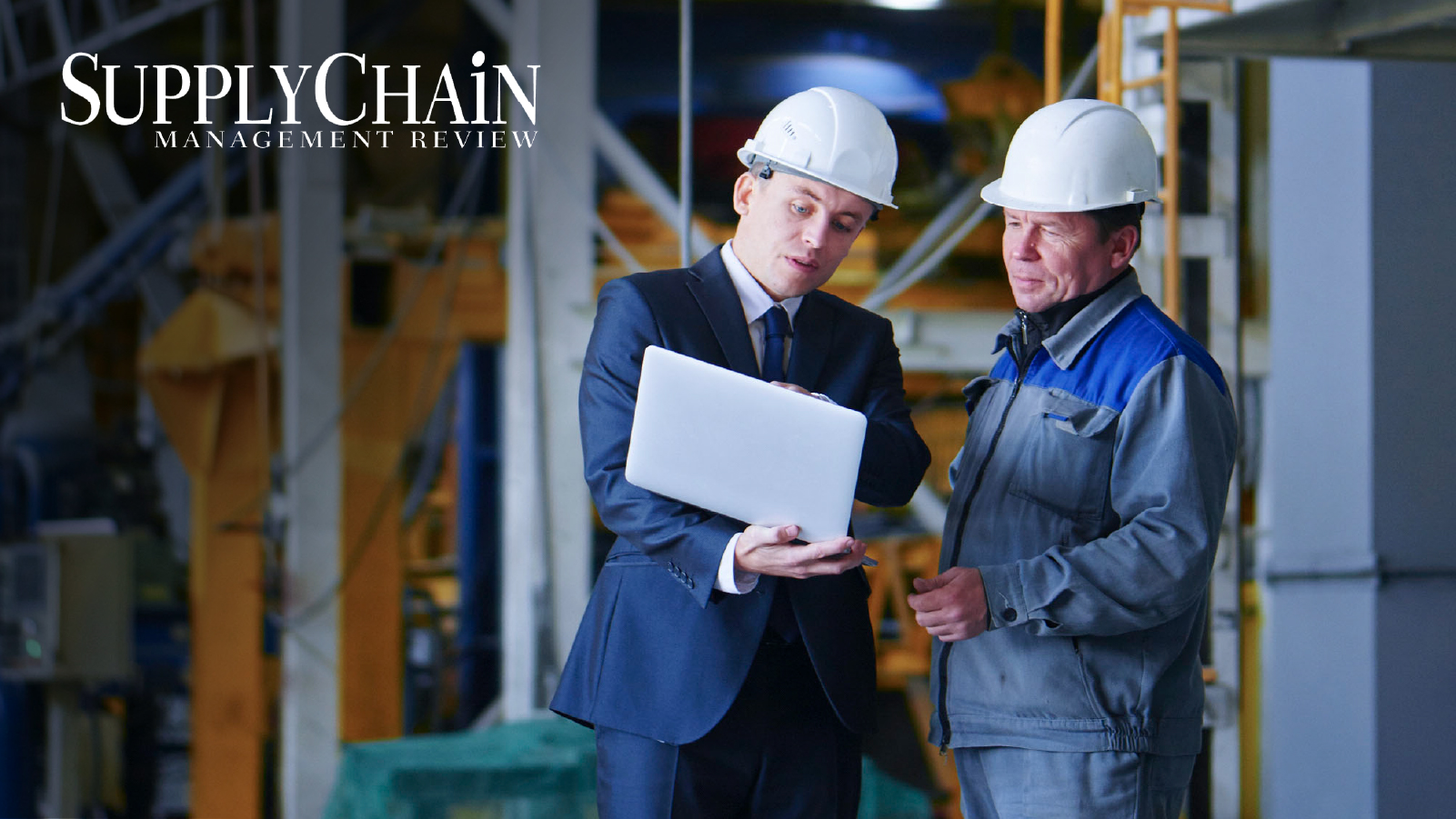 two men in hard hats collaborating over work at a construction site