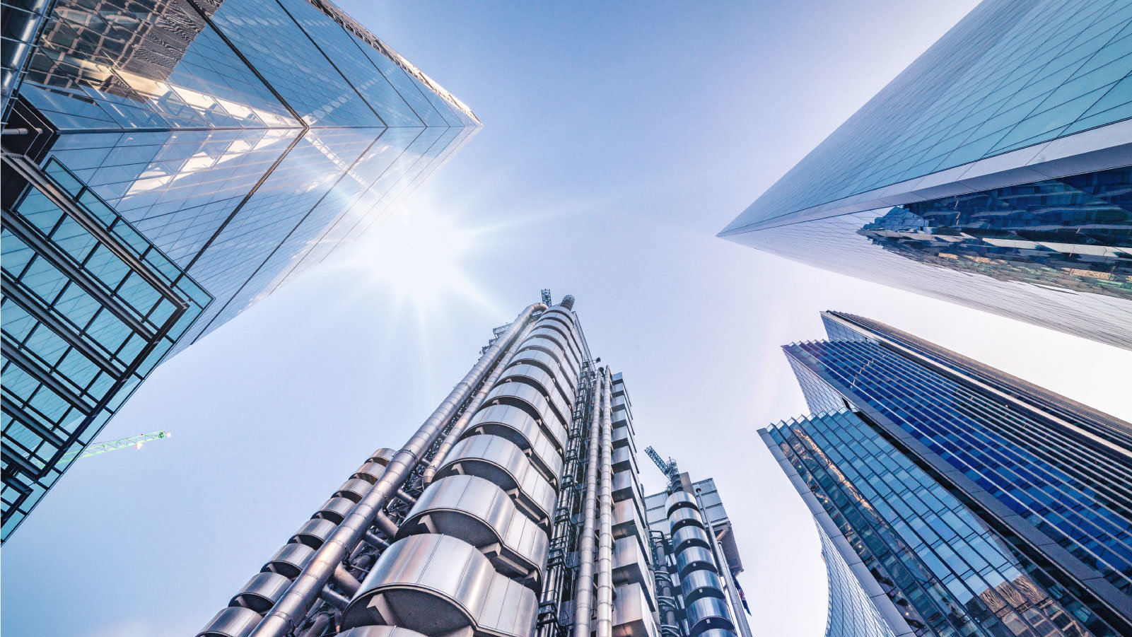 View upwards through skyscrapers toward the bright sun