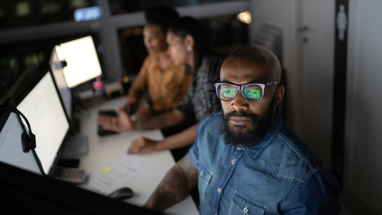 Men and women colleagues working at computer screens