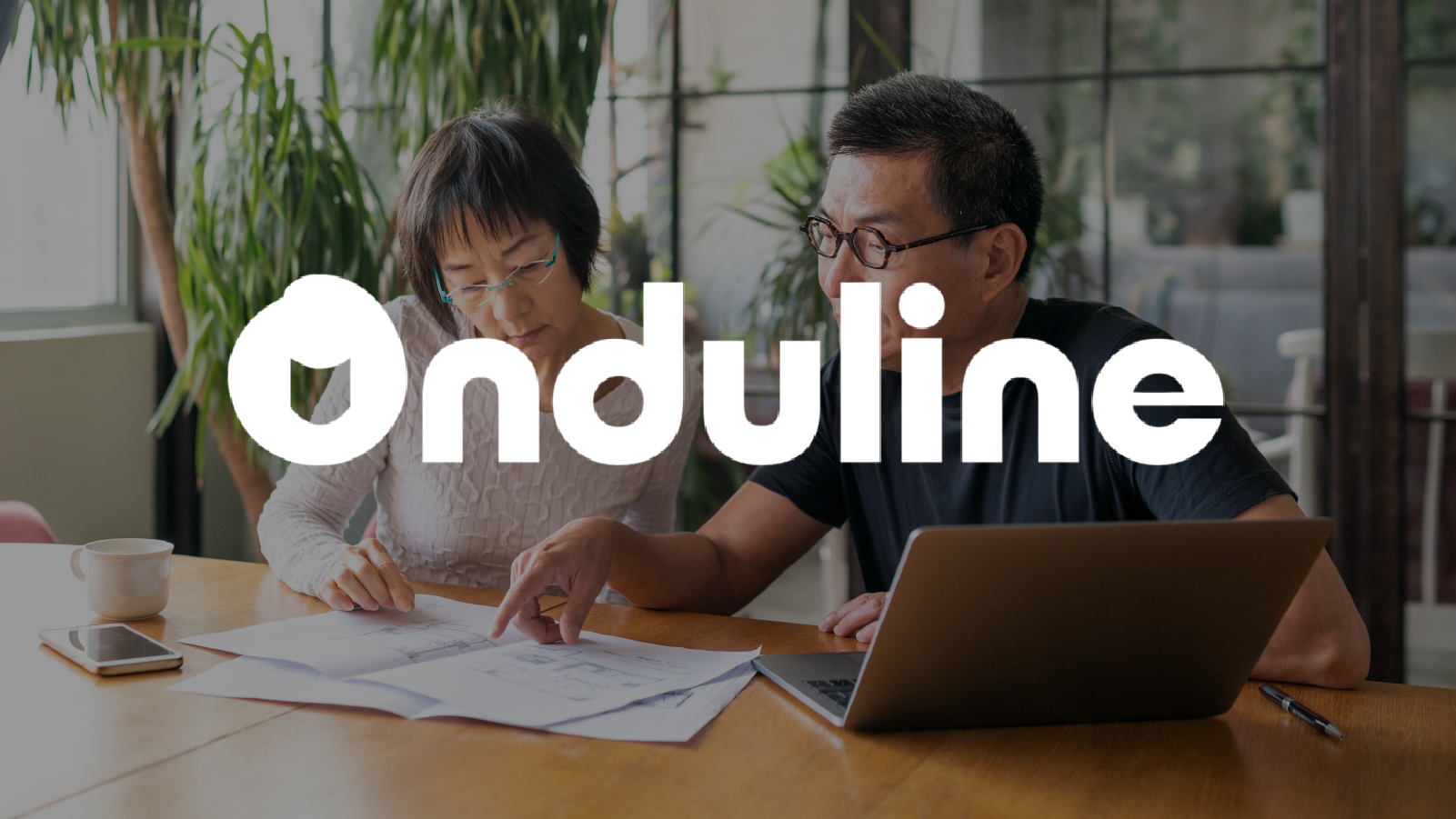 Onduline logo overlayed over two coworkers working together at a desk