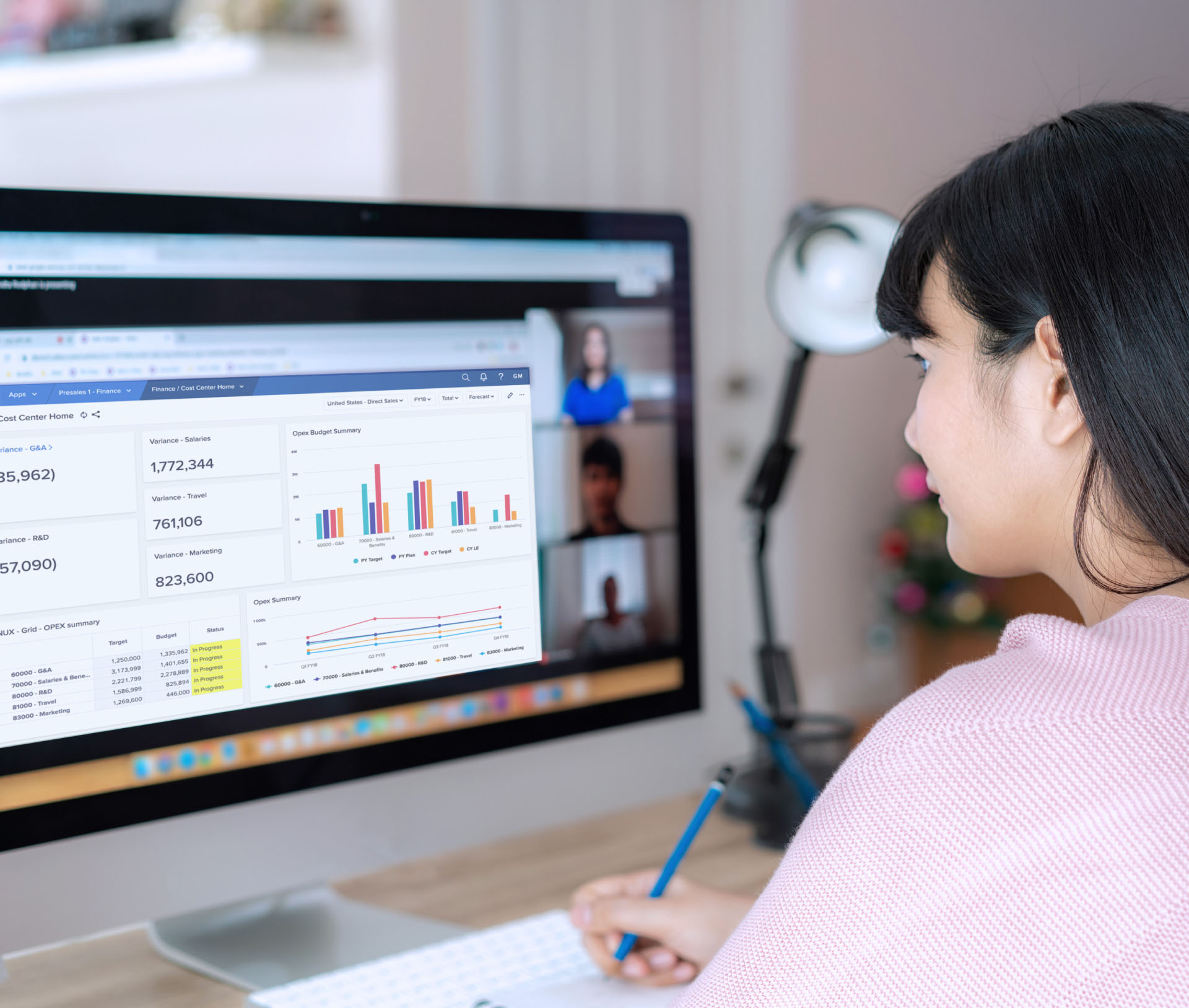 Business woman using Anaplan software, bar charts representing prediction models, on an iMac