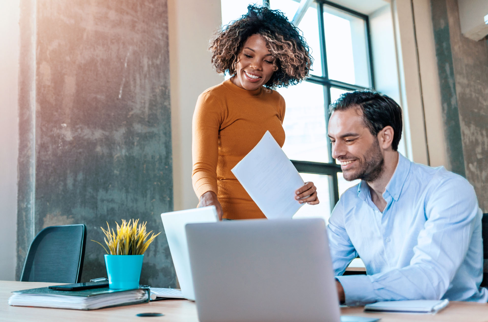 Man and woman looking at computer and smiling